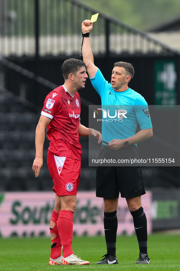 Referee Martin Woods shows a yellow card to Seb Quirk of Accrington Stanley during the Sky Bet League 2 match between Notts County and Accri...