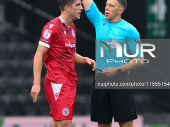 Referee Martin Woods shows a yellow card to Seb Quirk of Accrington Stanley during the Sky Bet League 2 match between Notts County and Accri...