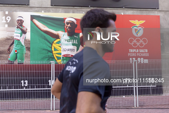 A person runs by pictures of Olympians at the Benfica ''Estadio da Luz'' in Lisbon, Portugal, on September 7, 2024. The soccer team has a ne...