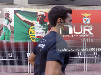 A person runs by pictures of Olympians at the Benfica ''Estadio da Luz'' in Lisbon, Portugal, on September 7, 2024. The soccer team has a ne...