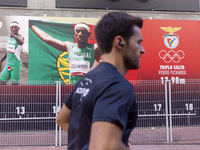 A person runs by pictures of Olympians at the Benfica ''Estadio da Luz'' in Lisbon, Portugal, on September 7, 2024. The soccer team has a ne...