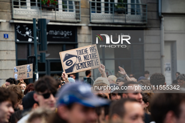 A protestor holds a placard reading, 'touche pas a notre poste' as he takes part in a demonstration after the appointment of a right-wing pr...