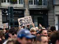 A protestor holds a placard reading, 'touche pas a notre poste' as he takes part in a demonstration after the appointment of a right-wing pr...