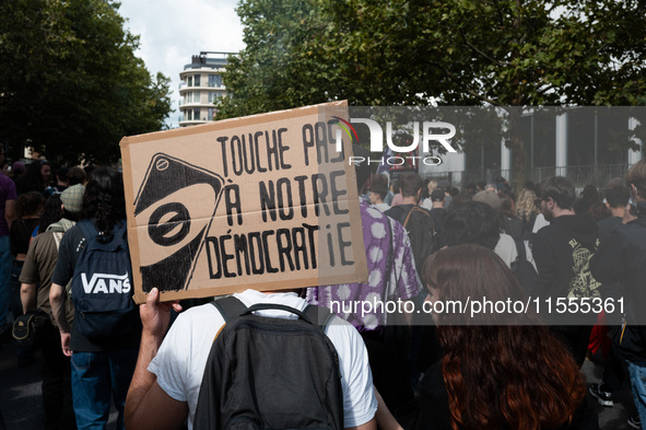 A protestor holds a placard reading, 'touche pas a notre democratie' as he takes part in a demonstration after the appointment of a right-wi...