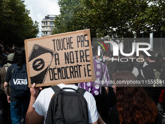 A protestor holds a placard reading, 'touche pas a notre democratie' as he takes part in a demonstration after the appointment of a right-wi...