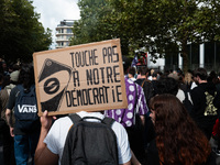 A protestor holds a placard reading, 'touche pas a notre democratie' as he takes part in a demonstration after the appointment of a right-wi...