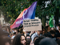 A protestor holds a placard reading, 'Macron-Barnier deni de democratie en bande organisee' as he takes part in a demonstration after the ap...