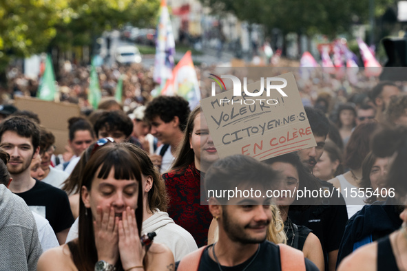 A protestor holds a placard reading, 'Macron the thief!! angry citizens' as he takes part in a demonstration after the appointment of a righ...