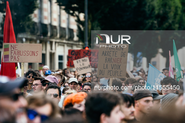 A protestor holds a placard reading, 'Macron arrete de Barnier la voix du peuple' as he takes part in a demonstration after the appointment...