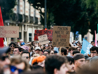 A protestor holds a placard reading, 'Macron arrete de Barnier la voix du peuple' as he takes part in a demonstration after the appointment...