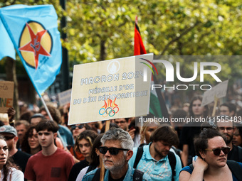 A protestor holds a placard reading, 'Macron 2024, medaille d'or du deni democratique' as he takes part in a demonstration after the appoint...