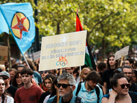 A protestor holds a placard reading, 'Macron 2024, medaille d'or du deni democratique' as he takes part in a demonstration after the appoint...