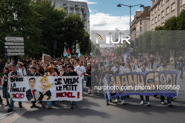 People march holding a banner that reads, 'In the fascist family, I want little Michel' and 'Manu Ciao', during a protest after the appointm...