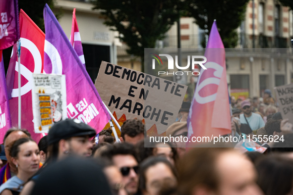 A protestor holds a placard reading, 'democratic en marche' as he takes part in a demonstration after the appointment of a right-wing prime...