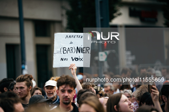 A protestor holds a placard reading, 'arretez de Barnier nos voix' as he takes part in a demonstration after the appointment of a right-wing...