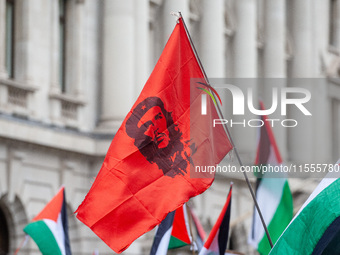 Pro-Palestinian activists and supporters wave a Palestinian flag featuring an image of Che Guevara as they march through London, United King...