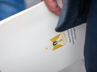 A member of the Palestinian Mission to the UK holds an official document during a Pro-Palestinian march through London, United Kingdom, on S...