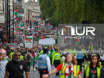 Pro-Palestinian activists and supporters wave Palestinian flags and hold placards as they march through London, United Kingdom, on September...