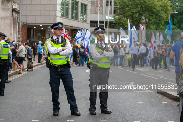 Metropolitan Police officers in London, United Kingdom, stand in front of pro-Israel protesters during the pro-Palestinian National Day of A...