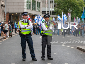 Metropolitan Police officers in London, United Kingdom, stand in front of pro-Israel protesters during the pro-Palestinian National Day of A...