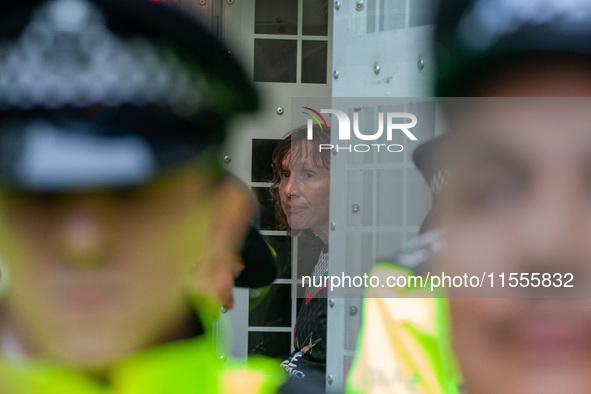 A pro-Palestinian activist sits in a police van after being arrested during the pro-Palestinian National Day of Action for Palestine in Lond...