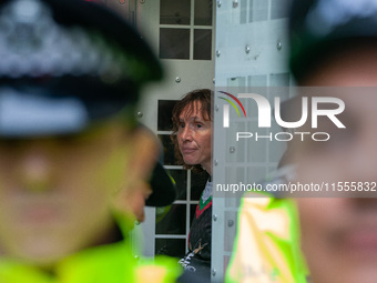 A pro-Palestinian activist sits in a police van after being arrested during the pro-Palestinian National Day of Action for Palestine in Lond...