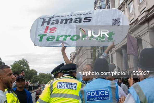 Police officers attempt to restrain a pro-Israel demonstrator holding a placard, who is later arrested following the National Day of Action...