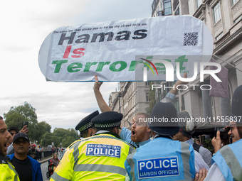 Police officers attempt to restrain a pro-Israel demonstrator holding a placard, who is later arrested following the National Day of Action...