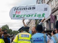 Police officers attempt to restrain a pro-Israel demonstrator holding a placard, who is later arrested following the National Day of Action...