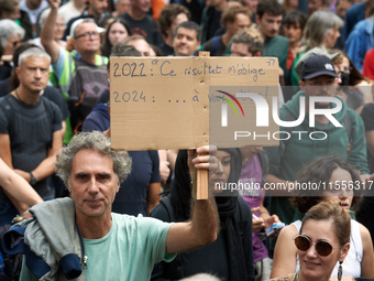 A man holds a cardboard sign reading '2022: your vote obliges me, 2024..to fuck you'. Between 5,000 and 8,000 protesters march in Toulouse a...