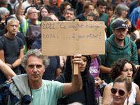 A man holds a cardboard sign reading '2022: your vote obliges me, 2024..to fuck you'. Between 5,000 and 8,000 protesters march in Toulouse a...