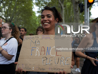 A young woman holds a placard reading 'My France weeps'. Between 5,000 and 8,000 protesters march in Toulouse and cities across France on Sa...