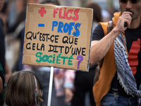 A protester holds a placard reading 'more cops, less profs, what does it say about a society?' Between 5,000 and 8,000 protesters march in T...