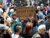 A man holds a cardboard sign reading 'Macron won again, only solution: revolution'. Between 5,000 and 8,000 protesters march in Toulouse, Fr...