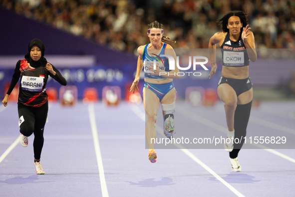 Karisma Tiarani of Indonesia, Martina Caironi of Italy, and Okoh Ndidikama of the UK compete in the Women's 100m - T63 Final at Stade de Fra...