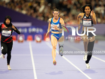 Karisma Tiarani of Indonesia, Martina Caironi of Italy, and Okoh Ndidikama of the UK compete in the Women's 100m - T63 Final at Stade de Fra...