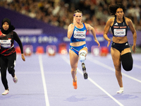 Karisma Tiarani of Indonesia, Martina Caironi of Italy, and Okoh Ndidikama of the UK compete in the Women's 100m - T63 Final at Stade de Fra...