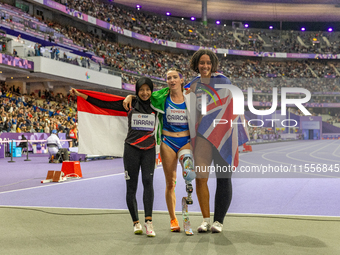 Karisma Tiarani of Indonesia, Martina Caironi of Italy, and Okoh Ndidikama of the UK react after the Women's 100m - T63 Final at Stade de Fr...