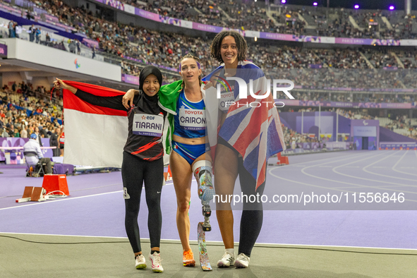 Karisma Tiarani of Indonesia, Martina Caironi of Italy, and Okoh Ndidikama of the UK react after the Women's 100m - T63 Final at Stade de Fr...