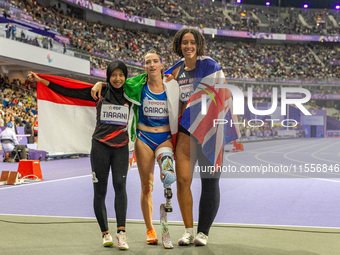 Karisma Tiarani of Indonesia, Martina Caironi of Italy, and Okoh Ndidikama of the UK react after the Women's 100m - T63 Final at Stade de Fr...