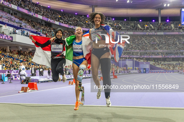 Karisma Tiarani of Indonesia, Martina Caironi of Italy, and Okoh Ndidikama of the UK react after the Women's 100m - T63 Final at Stade de Fr...