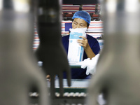 A worker produces disposable PVC gloves for domestic and international markets at a workshop of a foreign-funded enterprise in Suqian, China...