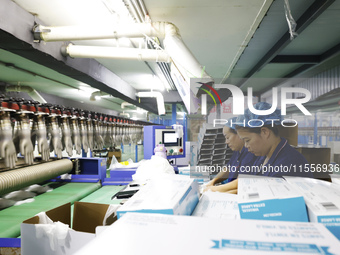 Workers make disposable PVC gloves for domestic and international markets at a production workshop of a foreign-funded enterprise in Suqian,...