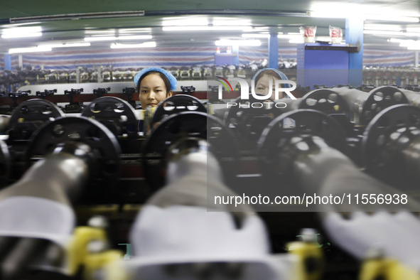 Workers make disposable PVC gloves for domestic and international markets at a production workshop of a foreign-funded enterprise in Suqian,...