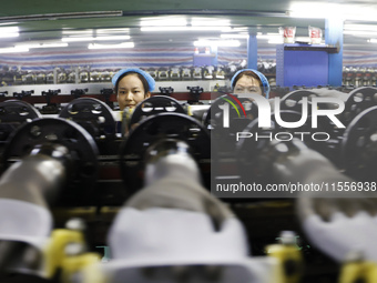 Workers make disposable PVC gloves for domestic and international markets at a production workshop of a foreign-funded enterprise in Suqian,...