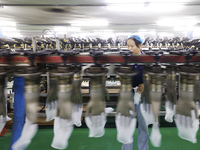 A worker produces disposable PVC gloves for domestic and international markets at a workshop of a foreign-funded enterprise in Suqian, China...