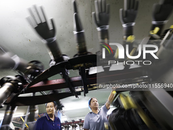 Workers make disposable PVC gloves for domestic and international markets at a production workshop of a foreign-funded enterprise in Suqian,...