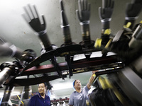 Workers make disposable PVC gloves for domestic and international markets at a production workshop of a foreign-funded enterprise in Suqian,...