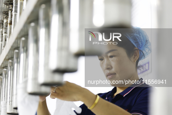 A worker produces disposable PVC gloves for domestic and international markets at a workshop of a foreign-funded enterprise in Suqian, China...