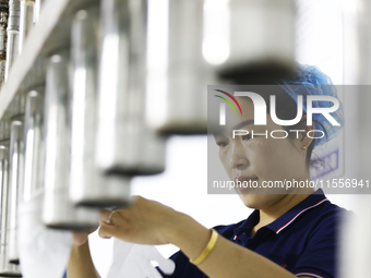 A worker produces disposable PVC gloves for domestic and international markets at a workshop of a foreign-funded enterprise in Suqian, China...